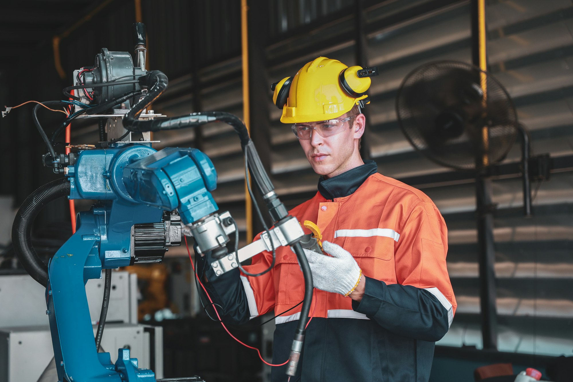 A Caucasian men Engineer Calibrating Robotic Equipment in Facility